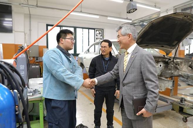 이기식 병무청장(오른쪽)이 12일 경기 시흥시 경기자동차과학고등학교에 방문해 실습하고 있는 학생을 격려하고 있다. 사진=병무청 제공