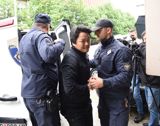 Police officers escort disgraced crypto company founder Do Kwon, center, in Podgorica, Montenegro, Thursday. [EPA/YONHAP]