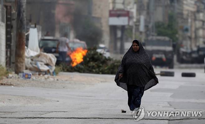 요르단강 서안지구의 팔레스타인인 (요르단강 서안 EPA=연합뉴스) 13일(현지시간) 요르단강 서안지구 도시 나블루스에서 한 여인이 거리를 걷고 있다. 2023.5.13 photo@yna.co.kr