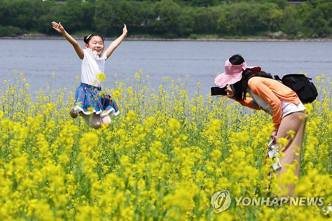 즐거운 유채꽃 나들이 (서울=연합뉴스) 서대연 기자 = 14일 서울 서초구 반포한강공원 서래섬에서 열린 2023 한강 서래섬 유채꽃 축제에서 한 어린이가 점프하며 기념사진을 찍고 있다. 2023.5.14 dwise@yna.co.kr