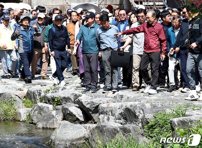 이명박 전 대통령이 15일 서울시장 재임 당시 청계천 복원사업에 함께했던 서울시 공무원 모임인 '청계천을 사랑하는 모임(청사모)' 구성원 등과 서울 청계천을 산책하고 있다. 청계천 복원사업은 이 전 대통령의 서울시장 재임 시절 대표적인 치적 중 하나로 꼽힌다. (공동취재) 2023.5.15/뉴스1 ⓒ News1 이승배 기자