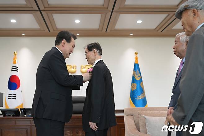 윤석열 대통령이 15일 용산 대통령실 자유홀에서 열린 제42회 스승의 날 기념 현장교원 초청 오찬 간담회에서 은사들에게 카네이션을 달아주고 있다. (대통령실 제공) 2023.5.15/뉴스1 ⓒ News1 오대일 기자