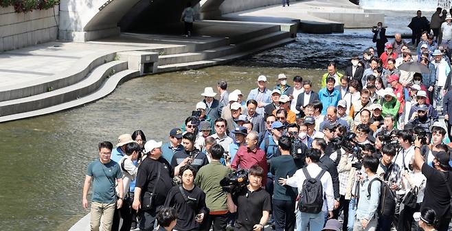 이명박 전 대통령이 15일 서울시장 재임 당시 청계천 복원사업에 함께했던 서울시 공무원 모임인 ‘청계천을 사랑하는 모임(청사모)’ 구성원 등과 서울 청계천을 산책하고 있다. (공동취재) 뉴스1