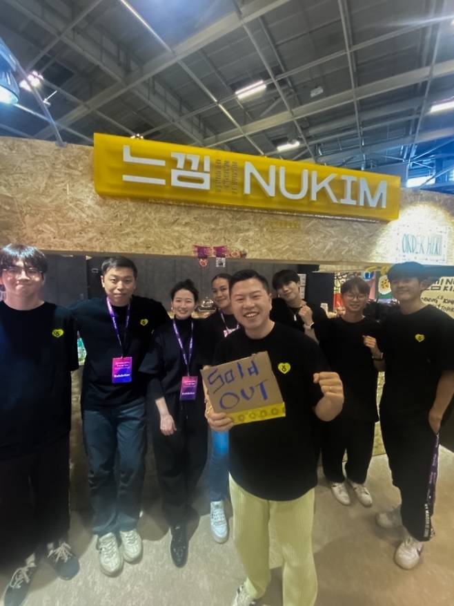 13일(현지시간) 프랑스 파리 포르트 드 베르사요 전시장서 열린 ‘2023 코리아 엑스포’에서 ‘느낌’의 관계자들이 품절(Sold out) 표지판을 들고 기념촬영하고 있다.