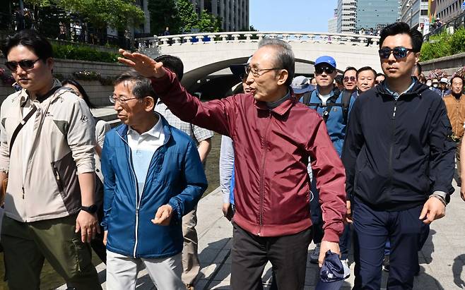 이명박 전 대통령이 15일 서울 청계천에서 '청계천을 사랑하는 모임'(청사모) 구성원들과 옛 참모들과 함께 산책하고 있다. 청계천 복원사업은 이 전 대통령의 서울시장 재임 시절 대표적인 치적 중 하나로 꼽힌다. [공동취재]