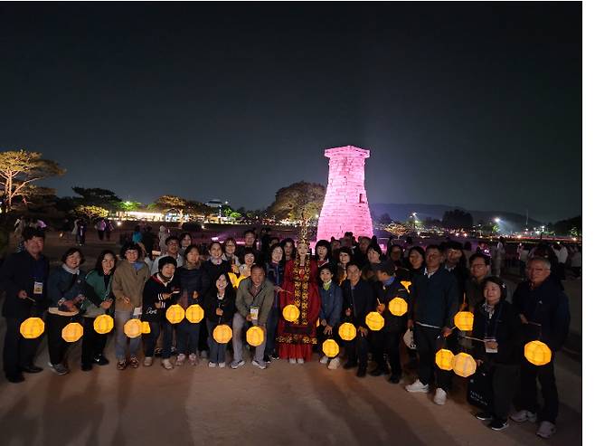 참가자들이 백등을 손에 들고 신라달빛기행 중 첨성대 앞에서 기념촬영을 하고 있다.