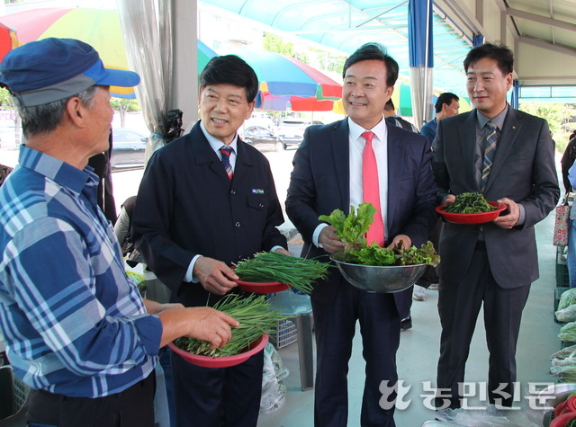 의왕시 농산물 직거래 장터를 찾은 김성제 의왕시장(오른쪽 두번째)과 김원석 NH농협 의왕시지부장(맨 오른쪽), 이응천 의왕농협 조합장(왼쪽 두번째)이 김재만 참여 농가 회장(맨 왼쪽)으로부터 설명을 듣고 있다.