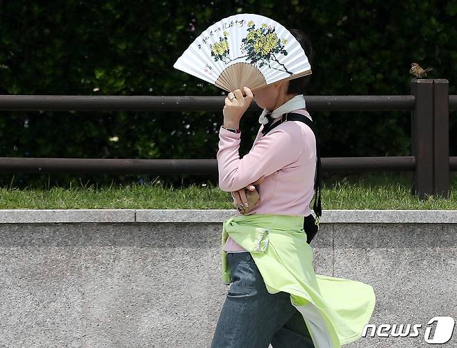 전국적으로 초여름 날씨를 보인 15일 오후 부산 해운대해수욕장에서 한 시민이 부채로 햇빛을 가리고 있다. 2023.5.15/뉴스1 ⓒ News1 윤일지 기자