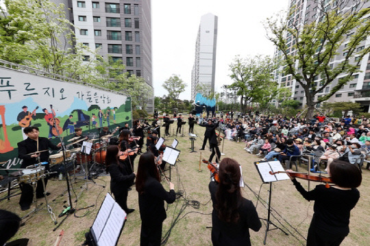 '영종센트럴푸르지오자이' 잔디광장에서 열린 '푸르지오 가든 음악회'에 참석한 입주민들이 공연을 즐기고 있다. <대우건설 제공>