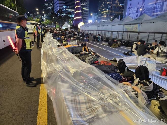 16일 오후 22시쯤 서울 종로구 청계광장 한편에 민주노총 조합원들이 업소용 포장비닐을 덮고 자고 있다. /사진=정세진 기자