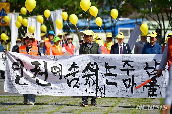 [광주=뉴시스] 이영주 기자 = 5·18민주화운동 43주기를 이틀 앞둔 16일 오전 광주 동구 소태동 주남마을에서 마을 주민과 자원봉사자들이 5·18 당시 주남마을에 암매장된 희생자들을 기리며 행진하고 있다.2023.05.16. leeyj2578@newsis.com