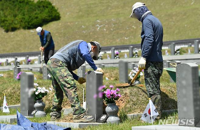 [광주=뉴시스] 김혜인 기자 = 16일 오전 광주 북구 운정동 국립 5·18민주묘지에서 관계자들이 묘지 보수를 하고 있다. 2023.05.16. hyein0342@newsis.com