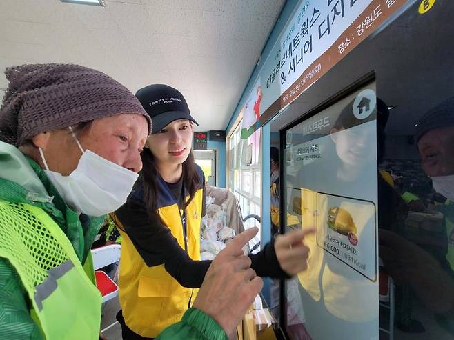 CJ올리브네트웍스 직원이 강원철원서 어르신께 키오스크 사용법을 교육하는 장면  [CJ올리브네트웍스 제공]