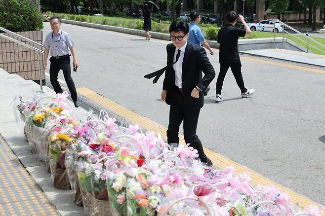 한동훈 법무부 장관이 취임 1년을 맞은 17일 오전 정부과천청사 법무부로 출근하고 있다. 이날 법무부 앞 계단에 지지자들이 보낸 축하 꽃다발이 수북이 놓여 있었다 (사진=연합뉴스)