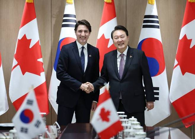 쥐스탱 트뤼도 캐나다 총리(왼쪽부터)와 윤석열 대통령이 정상회담에 앞서 악수를 나누고 있다.   사진=연합뉴스