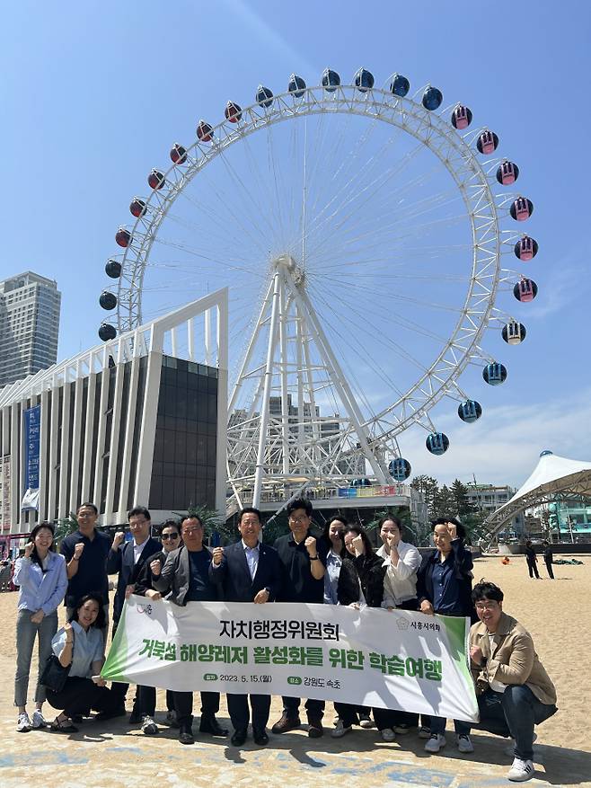 거북섬 해양레져 활성화를 위해 속초시를 방문한 박춘호 시흥시의회 자치행정위원장을 비롯한 관계자들이 국내 첫 해변 대관람차인 '속초아이'앞에서 기념촬영을 하고 있다. ⓒ시흥시 제공