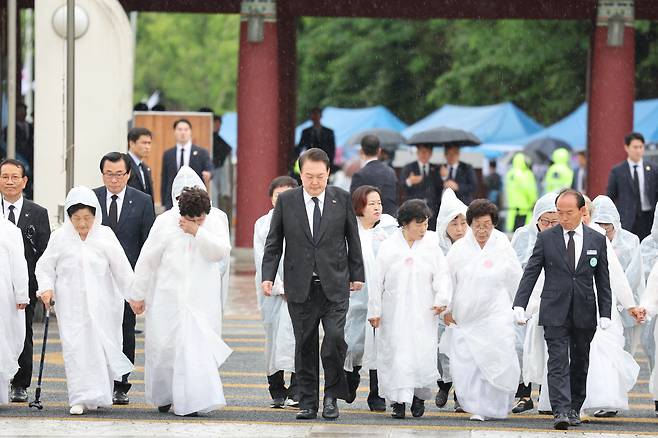 윤석열 대통령이 18일 광주광역시 북구 국립5·18민주묘지에서 열린 제43주년 5·18민주화운동 기념식에 오월어머니회 회원들과 함께 입장하고 있다. /연합뉴스