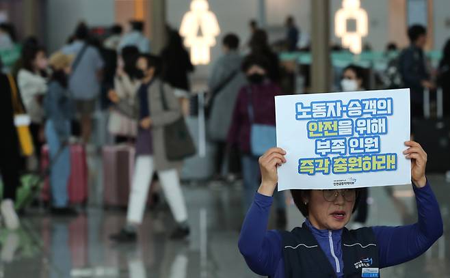 지난 2일 오전 인천국제공항 제1여객터미널 출국장에서 열린 ‘노동자·승객이 안전한 공항! 여름 성수기 대비 인천공항 현장 인력 충원 촉구 기자회견’에서 민주노총 공공운수노조 인천공항지역지부 회원이 피켓을 들고 있다.  연합뉴스