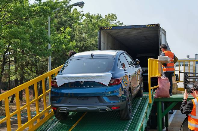 Renault Korea Motors’ export model of small-sized SUV XM3, named Arkana, is loaded into a container box in the carmaker’s Busan factory, Tuesday. (Renault Korea Motors)