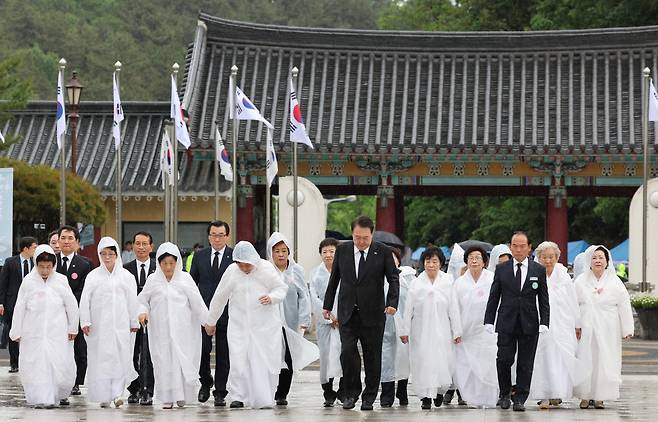 윤석열 대통령이 18일 광주 북구 국립5·18민주묘지에서 열린 제43주년 5·18민주화운동 기념식에 오월어머니회 회원들과 함께 입장하고 있다. [연합]