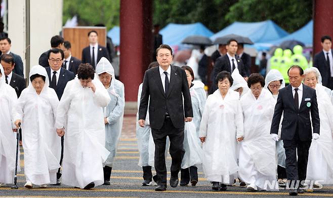 [광주=뉴시스] 홍효식 기자 = 윤석열 대통령이 18일 광주 북구 국립5·18민주묘지에서 열린 제43주년 5·18민주화운동 기념식에 오월어머니회 회원들과 함께 입장하고 있다. (대통령실통신사진기자단) 2023.05.18. yesphoto@newsis.com