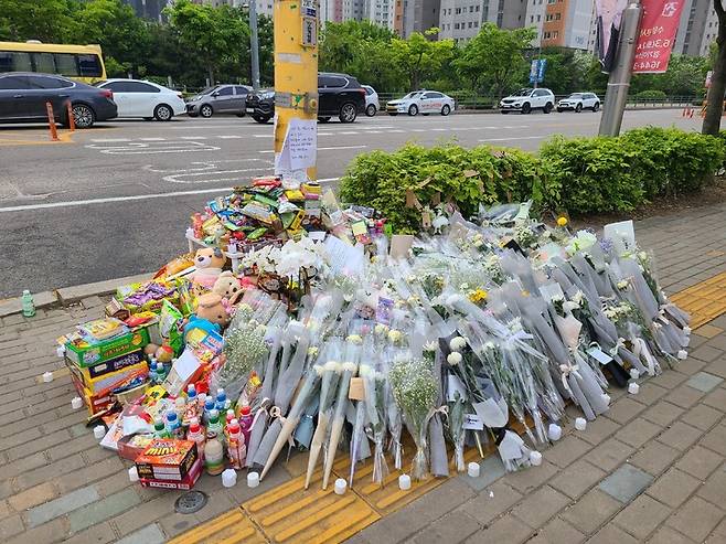 [수원=뉴시스] 양효원 기자 = 경기 수원시 호매실동 사거리에서 신호를 위반한 버스에 초등학생이 치여 사망한 사고지점에 꽃과 간식 등이 놓여있다. 2023.5.12. hyo@newsis.com *재판매 및 DB 금지