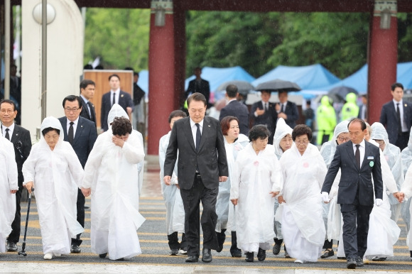 오월어머니회와 함께 입장하는 윤석열 대통령 - 윤석열 대통령이 18일 광주 북구 국립5·18민주묘지에서 열린 제43주년 5·18민주화운동 기념식에 오월어머니회 회원들과 함께 입장하고 있다. 2023.5.18  연합뉴스