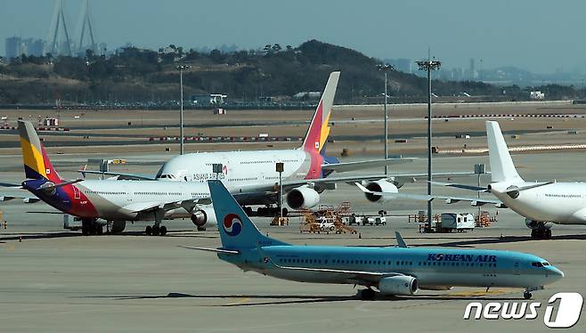 19일 오후 인천국제공항 전망대에서 바라본 계류장에서 대한항공 항공기가 아시아나항공 항공기 앞을 지나고 있다. 2023.2.19/뉴스1 ⓒ News1 박정호 기자