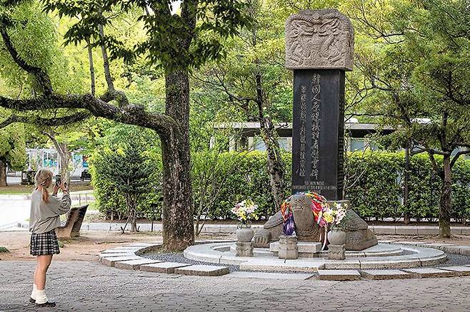 한반도 방향 바라보는 거북이 받침석 - 일본 히로시마 평화기념공원에 설치된 한국인 원폭 희생자 위령비 앞에서 지난 14일 한 여성이 사진을 찍고 있다. 윤석열 대통령과 기시다 후미오 일본 총리는 히로시마에서 열리는 7국(G7) 회의 기간(19~21일) 이 위령비에 공동 참배할 예정이다. /AFP 연합뉴스