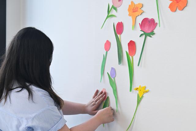 혜림씨가 자신이 그린 꽃들을 작업실 벽에 붙이고 있다. 2019년 ‘서울일러스트레이션페어’에 참여했을 때 그린 꽃들이다. 당시 정원을 생각하며 행어에 꽃들을 달아 전시했다. 최주연 기자