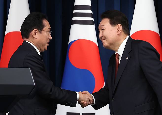 President Yoon Suk Yeol (right) and Japanese Prime Minister Fumio Kishida shake hands during a joint news conference following their summit at the presidential office in Seoul on May 7. (Yonhap)