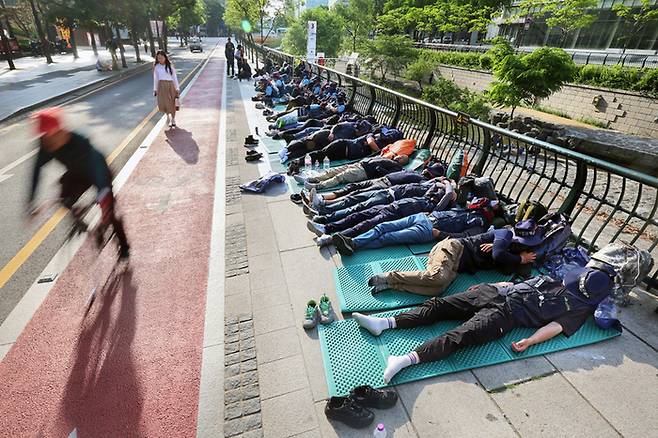 민주노총 건설노조가 지난 16일부터 1박2일에 걸쳐 서울 도심 한복판에서 총파업 결의대회를 강행하면서 불편을 호소하는 시민들의 112 신고가 빗발쳤다. 17일 오전 출근시간대에 서울 청계광장에서 노조원들이 노숙을 하고 있다. 현행 경범죄처벌법에 따르면 인도를 점유해 노숙하는 행위에 대해선 별다른 처벌 규정이 없다.  [사진 = 연합뉴스]