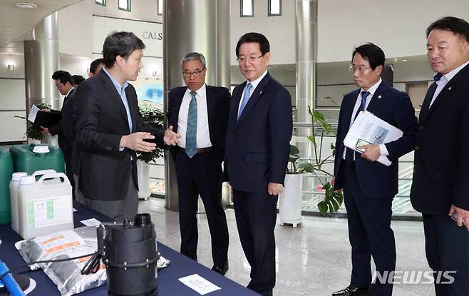 [서울=뉴시스] 이창우 기자=김영록 전남도지사(오른쪽 세 번째)가 19일 오후 서울대학교 대회의실에서 열린 신규 김 활성처리제 후보물질·부가장치 개발 연구용역 성과보고회에서 분말형 활성처리제와 옥살산 처리제를 살펴보고 있다. (사진=전남도 제공) 2023.05.19. photo@newsis.com *재판매 및 DB 금지