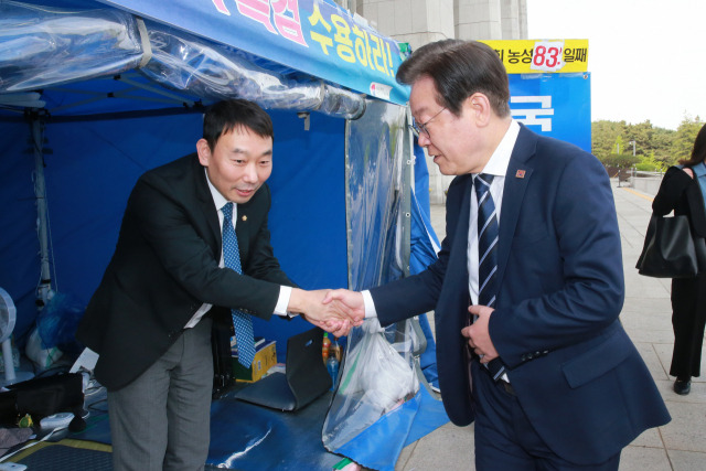 지난달 24일 이재명 더불어민주당 대표가 국회 본관 앞에서 천막 농성 중인 김용민 의원과 악수하고 있다. 연합뉴스