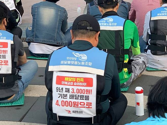 ‘배달의민족 단체교섭 승리를 위한 촛불집회’가 열린 5월 17일 서울 송파구 우아한형제들 사옥 앞에서 민주노총 서비스연맹 배달플랫폼노조 조합원들이 9년째 동결된 기본 배달료 3천원을 인상하라고 촉구하고 있다. 배달플랫폼노조 제공