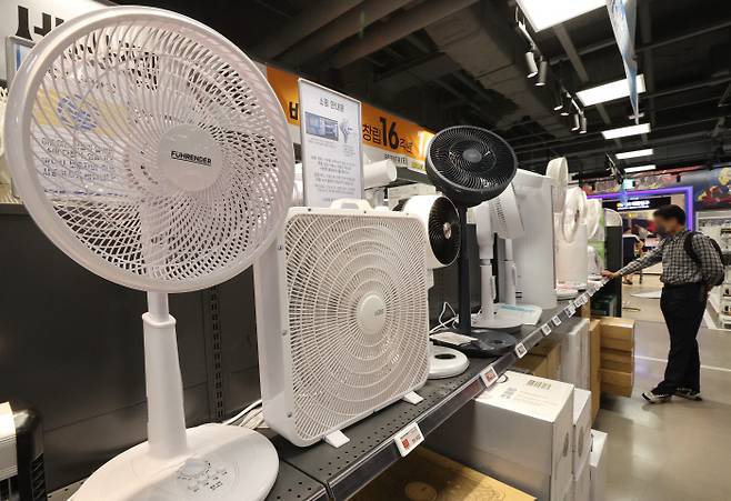 한 시민이 21일 서울 한 대형마트에서 선풍기를 살펴보고 있다. 올 여름 폭염이 예상되는 가운데 전기요금이 인상돼 선풍기 매출이 늘고 있다. 연합뉴스