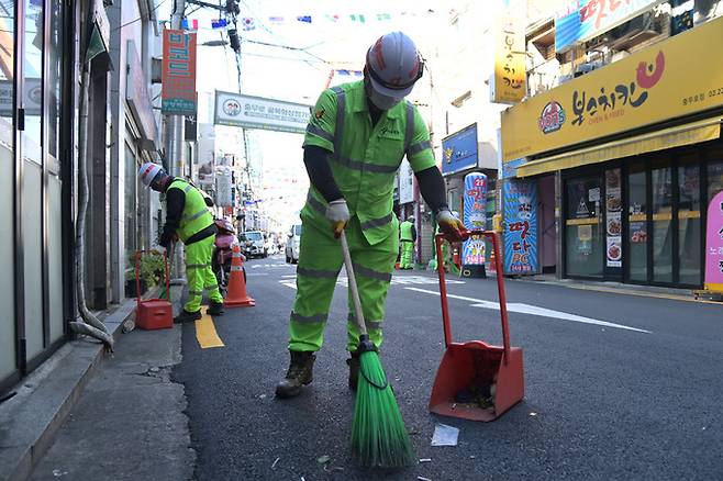 서울 중구의 한 이면도로에서 환경미화원들이 청소 작업을 하고 있는 모습. 중구 제공