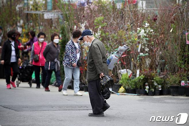 식목일을 하루 앞둔 4일 오후 서울 종로구 종로꽃시장을 찾은 한 시민이 묘목을 구입해 발걸음을 옮기고 있다. /사진=뉴스1