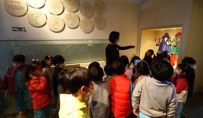 박물관 학예사가 어린이들에게 돌잡이 문화 등 전시물에 관해 설명하고 있다.