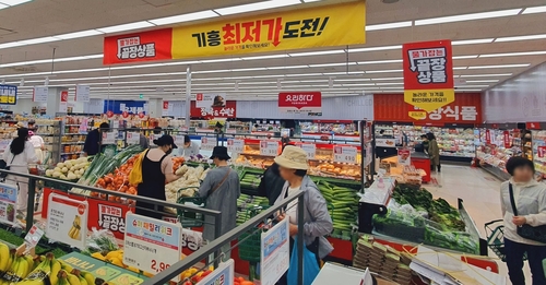 고객이 롯데슈퍼 언남점에서 상품을 구매하고 있다.