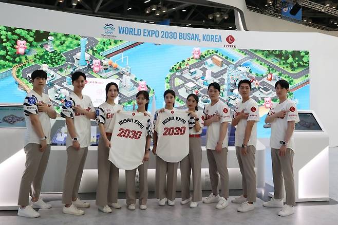 롯데그룹관에서 직원들이 'BUSAN EXPO 2030'이 새겨진 친환경 유니폼을 착용하고 2030 부산세계박람회 유치 홍보 활동을 하고 있다. 롯데지주 제공