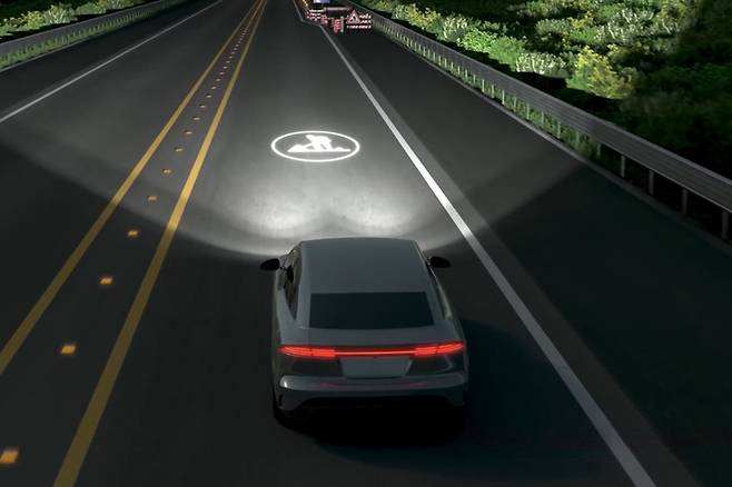 현대모비스가 개발한  HD  라이팅 시스템이 도로에 공사중 기호를 표시하고 있다.  현대모비스 제공