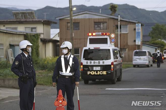 [나카노=AP/뉴시스]25일 일본 중부 나가노현 나카노시에서 경찰관들이 한 남성이 은신해 있는 건물로 향하는 거리에서 경계근무를 서고 있다. 2023.05.26.