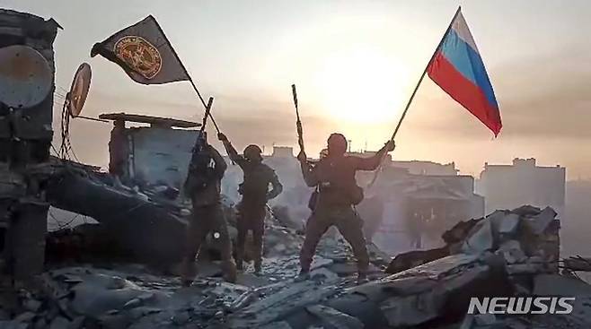 [바흐무트=AP/뉴시스] 러시아 용병 기업 바그너 그룹이 공개한 사진에 지난 20일 바그너그룹 소속 군인이 우크라이나 바흐무트의 손상된 건물 위에서 러시아 국기와 바그너 깃발을 흔들고 있다. 이 그룹 수장 예브게니 프리고진은 러-우크라이나 전쟁 중 가장 길고도 치열한 전투 끝에 그의 군대가 바흐무트를 장악했다고 주장했으며 우크라이나 국방부는 이를 부인했다. 프리고진은 텔레그램에 올린 영상에서 바흐무트가 토요일 정오 완전히 점령됐다고 밝혔다. 2023.05.26.