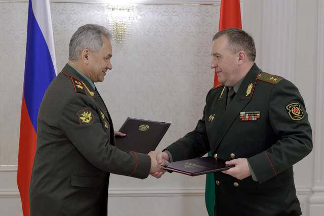 ▲25일(현지시각) 벨라루스 민스크에서 회담을 가진 세르게이 쇼이구 러시아 국방장관(왼쪽)과 빅토르 크레닌 벨라루스 국방장관이 악수하고 있다. 이날 양국 국방장관은  러시아 전술핵무기를 벨라루스 영토 내 배치하는 협약에 서명했다. ⓒUPI=연합뉴스 