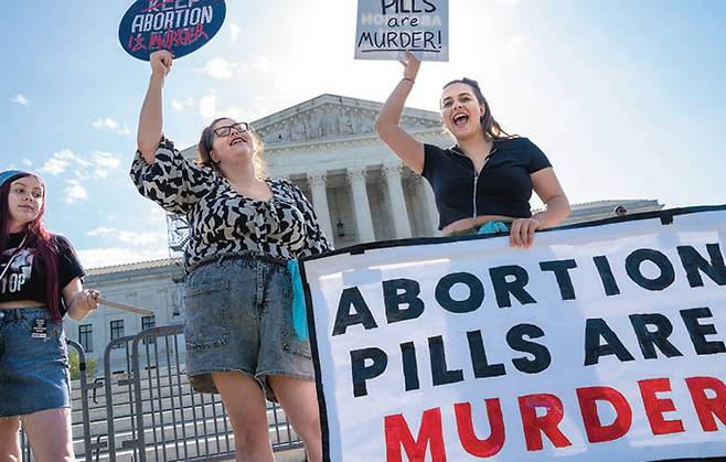 지난달 21일(현지 시간) 미국 워싱턴주 주 대법원 앞에서 낙태 반대 단체 소속 시위자들이 ‘낙태약은 살인(abortion pills are murder)’이라는 문구가 적힌 팻말을 들고 있다.