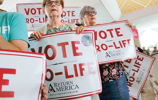 16일(현지 시간) 미국 노스캐롤라이나주 롤리에 있는 주 상원 의사당 앞에서 낙태 반대 시위자들이 ‘생명을 위해 투표해라(vote pro-life)’라는 문구가 담긴 팻말을 들고 시위하고 있다.
