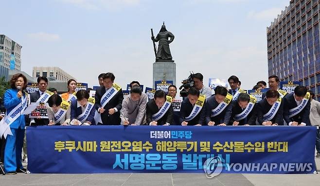 더불어민주당 이재명 대표와 지도부가 26일 오전 서울 광화문광장 이순신장군 동상 앞에서 열린 후쿠시마 원전 오염수 해양투기 및 수산물 수입 반대 국민서명운동 발대식에서 서명하고 있다.  [사진 = 연합뉴스]