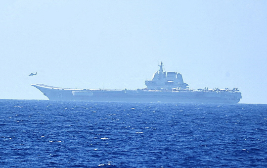 지난 4월 17일 일본 오키나와 남쪽의 태평양 해상에서 헬기가 이륙하고 있는 중국의 항공모함 산둥함의 모습. 로이터·뉴시스 자료사진·일본 방위성 제공
