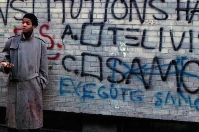 장 미쉘 바스키아가 그라피티 앞에 선 모습.